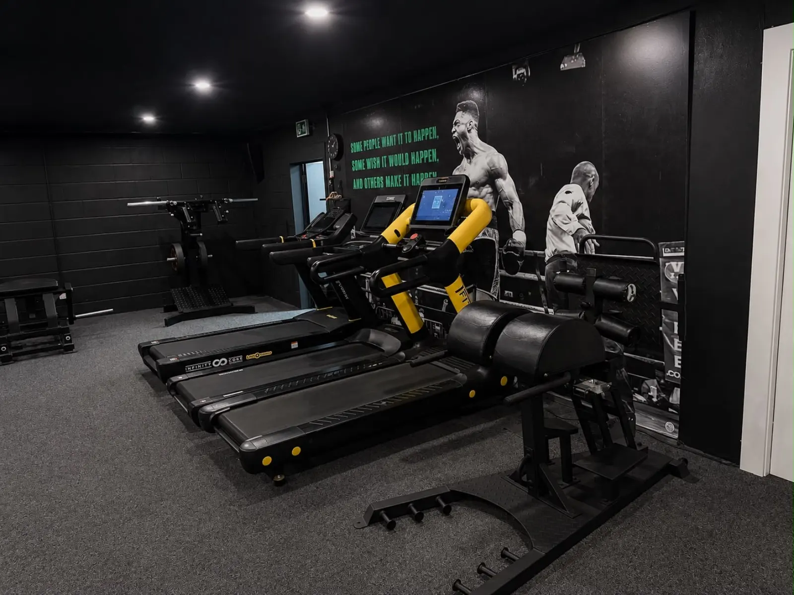 Cardio zone with treadmills and boxing wall art in the TNT Fitness studio